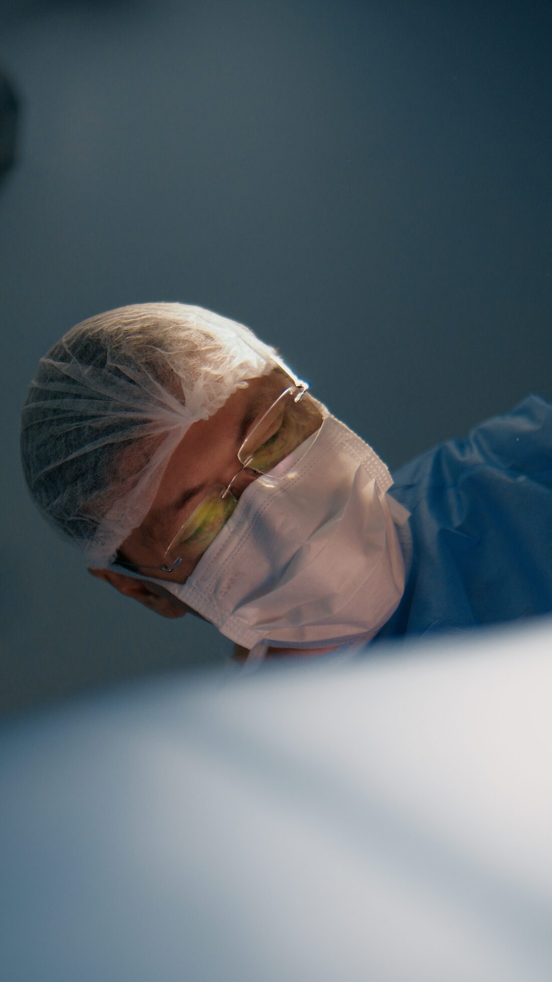 Dr. Nasser Mahfouz de perfil, concentrado durante uma cirurgia vascular
